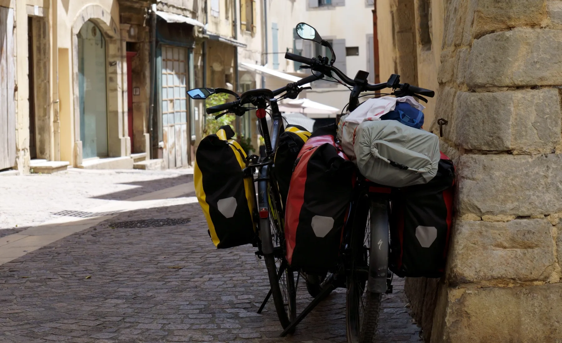 Fahrrad, das mit Reisetaschen an eine Wand gelehnt wird